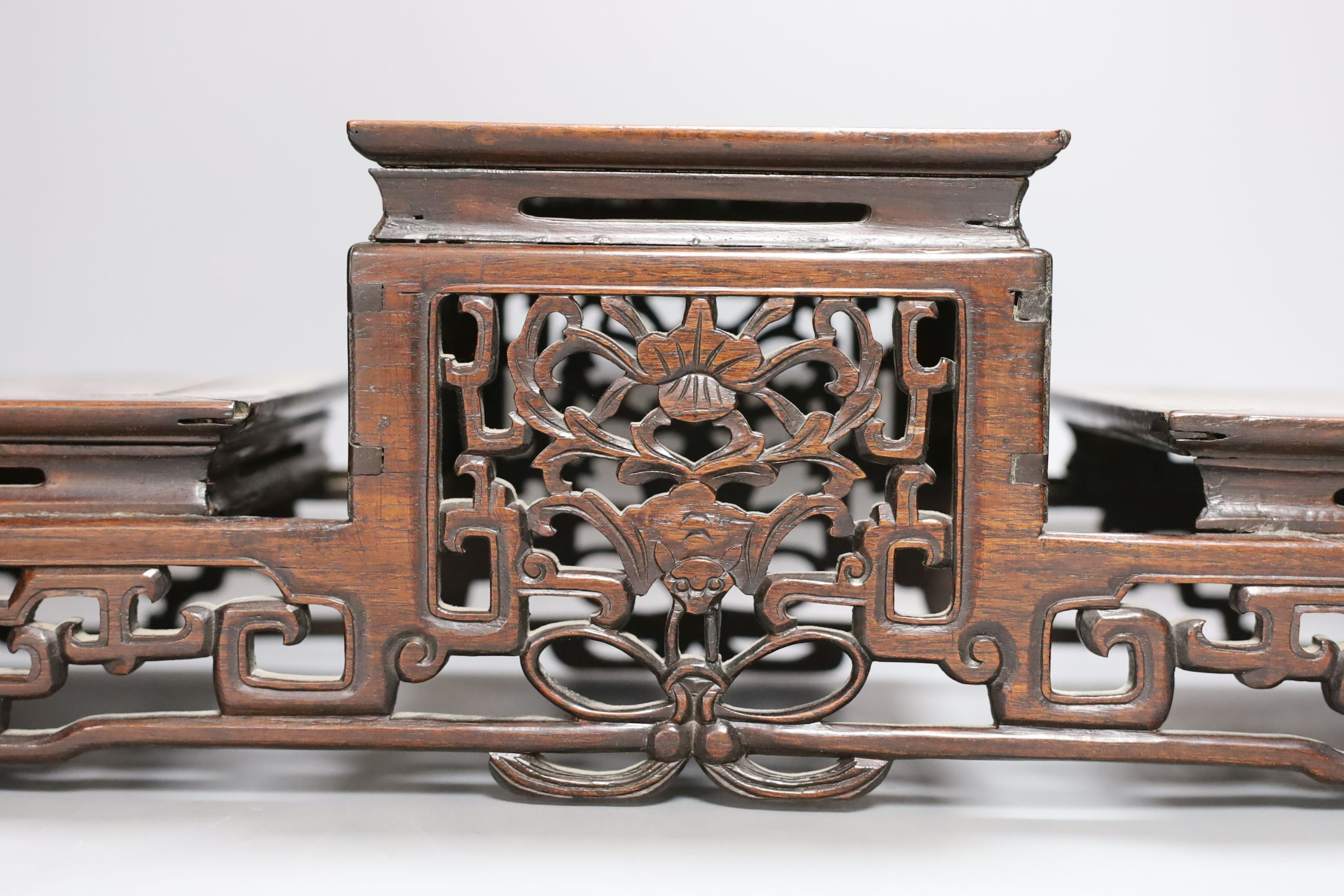 A Chinese carved hardwood 3 tier stand, late Qing, together with other similar stands. Largest 49cm